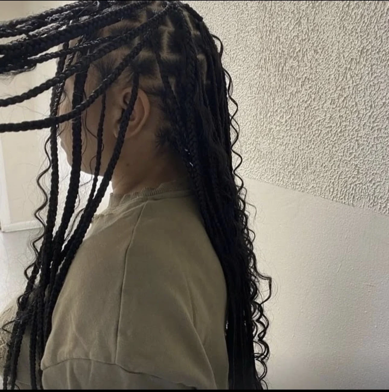 Side view of boho knotless braids with curly accents by Elegant African Braiding